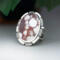 3/4 view facing left large oval wild horse magnesite gemstone silver statement ring, bezel set with stamped cutout wire accent